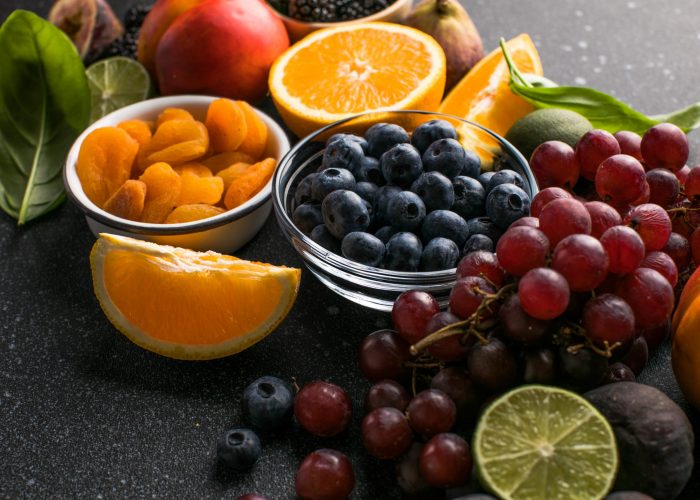 Assortment of fresh exotic fruits and berries on concrete table, flat lay