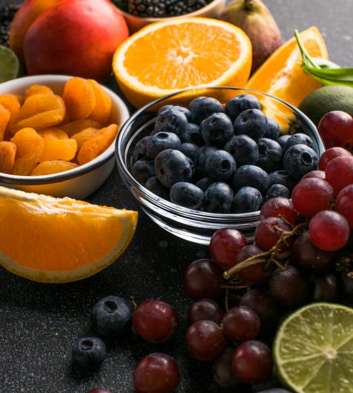 Assortment of fresh exotic fruits and berries on concrete table, flat lay